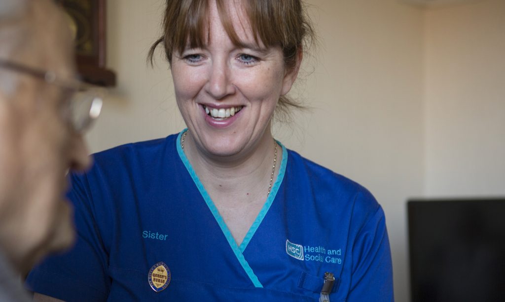 A district nurse helps a patient with breathing difficulties