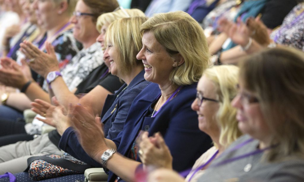 An audience at conference clapping