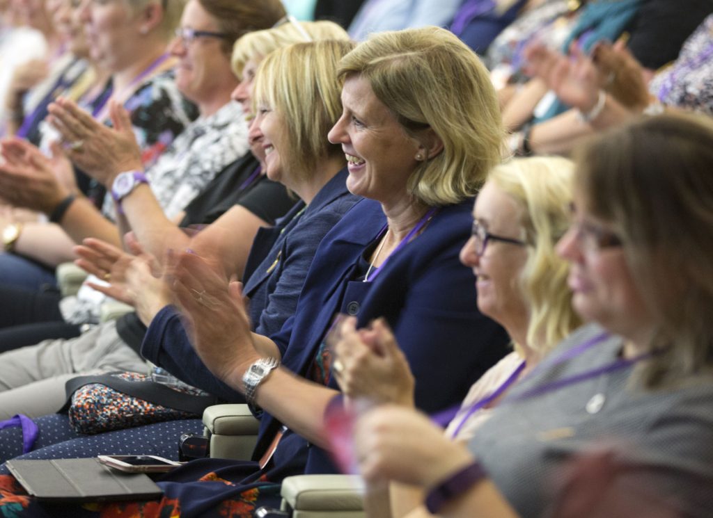 An audience at conference clapping