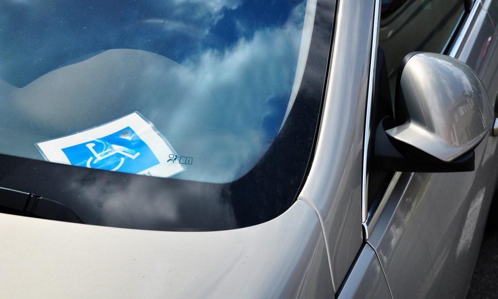 Disabled driver sign in windscreen of a silver car