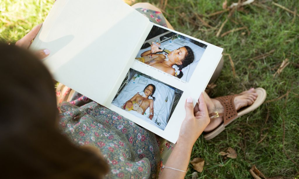 A young woman looks at a photo album of her hospitalisation