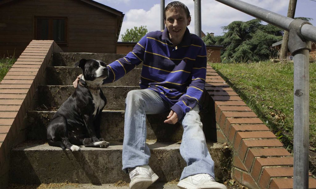Homeless man with his dog sitting on steps