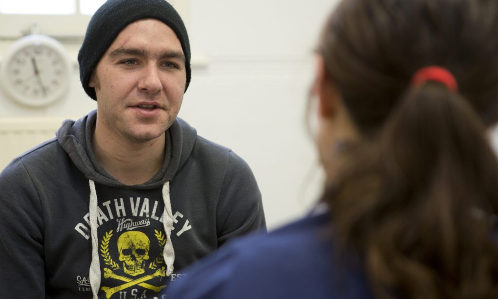 A homeless man in consultation with a nurse