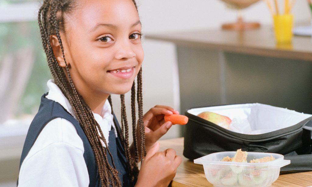 A school girl eats her packed lunch
