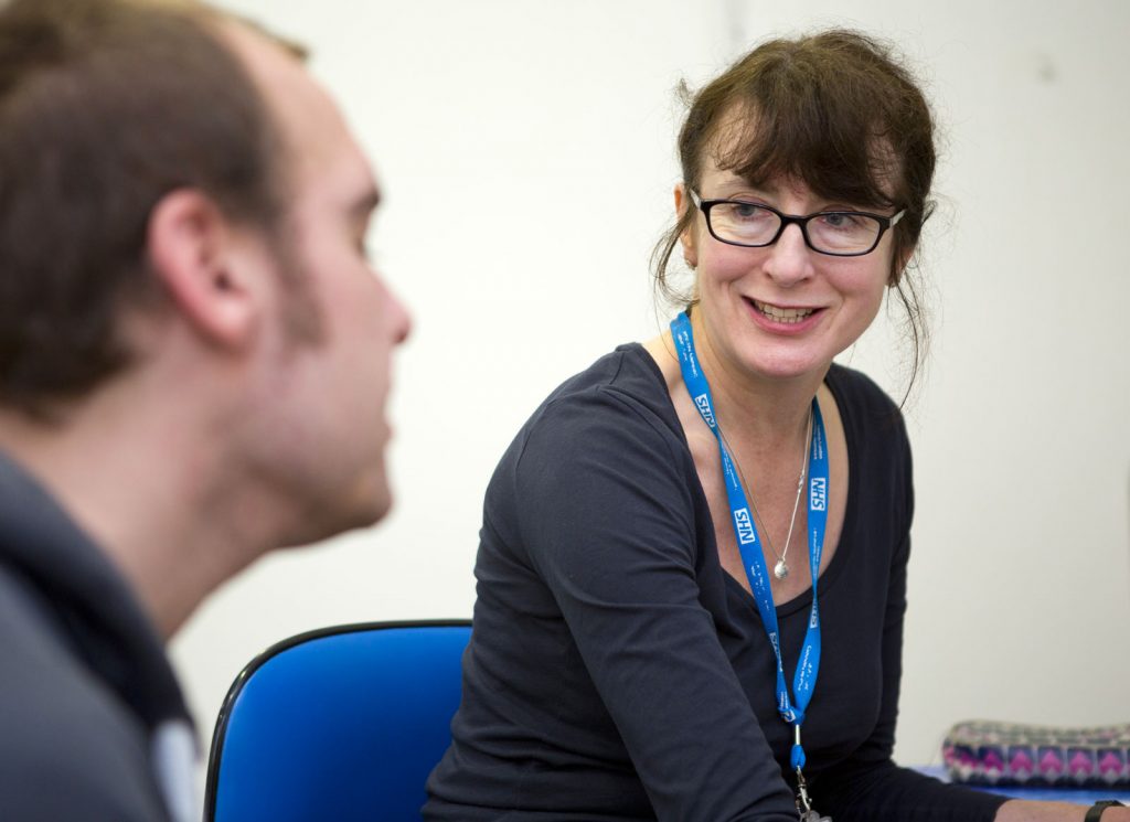 Nurse wearing glasses consulting with a homeless patient