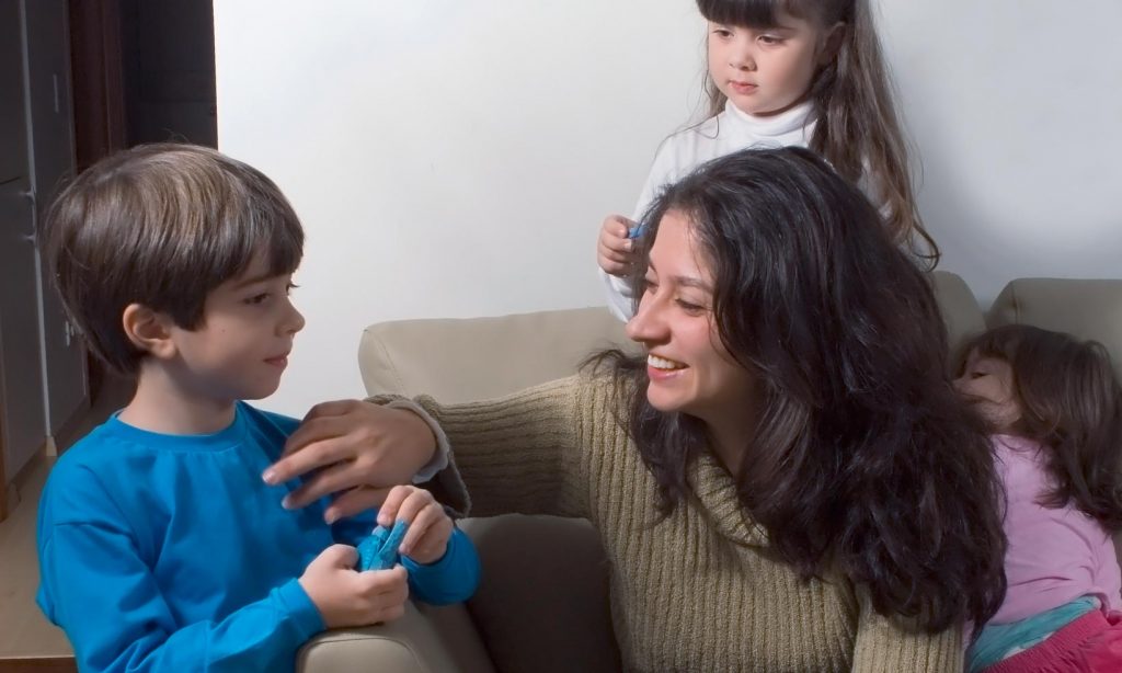 A single mum with 3 kids playing on a sofa