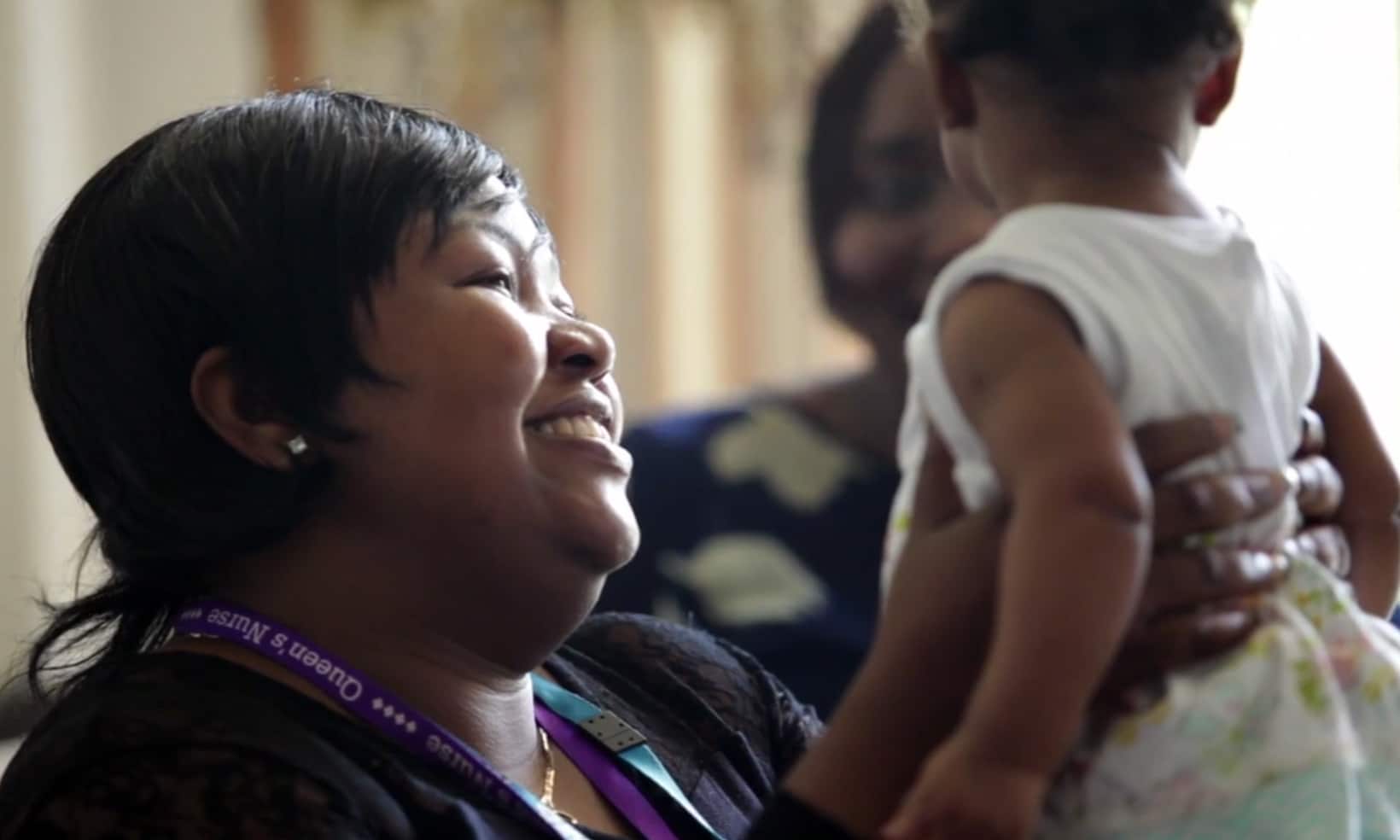 A health visitor holds up a baby