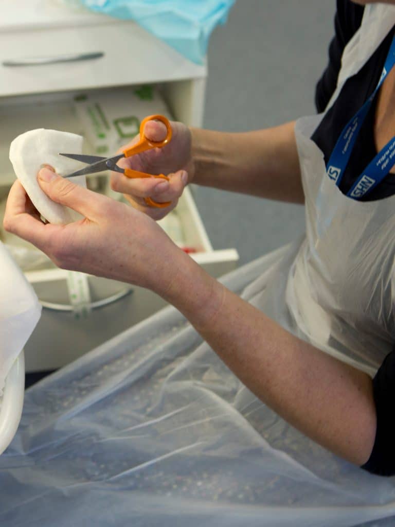 Nurse preparing a bandage for a wound