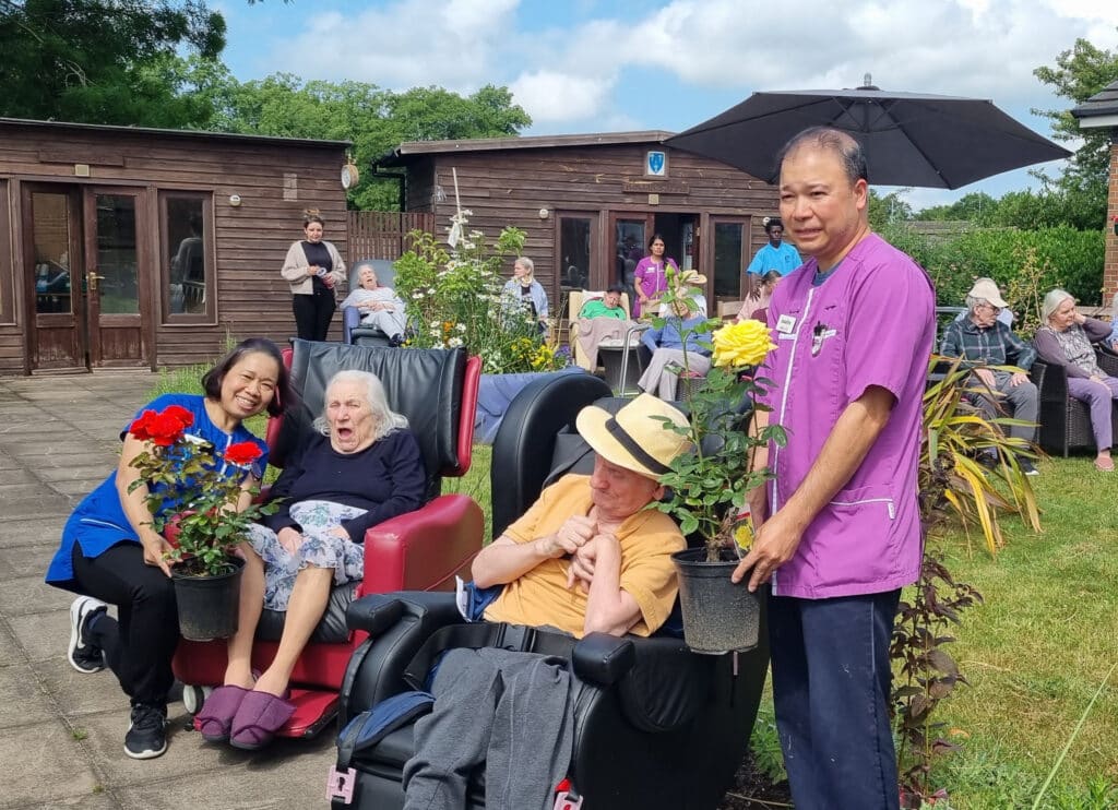 Nurse with residents in a care home garden